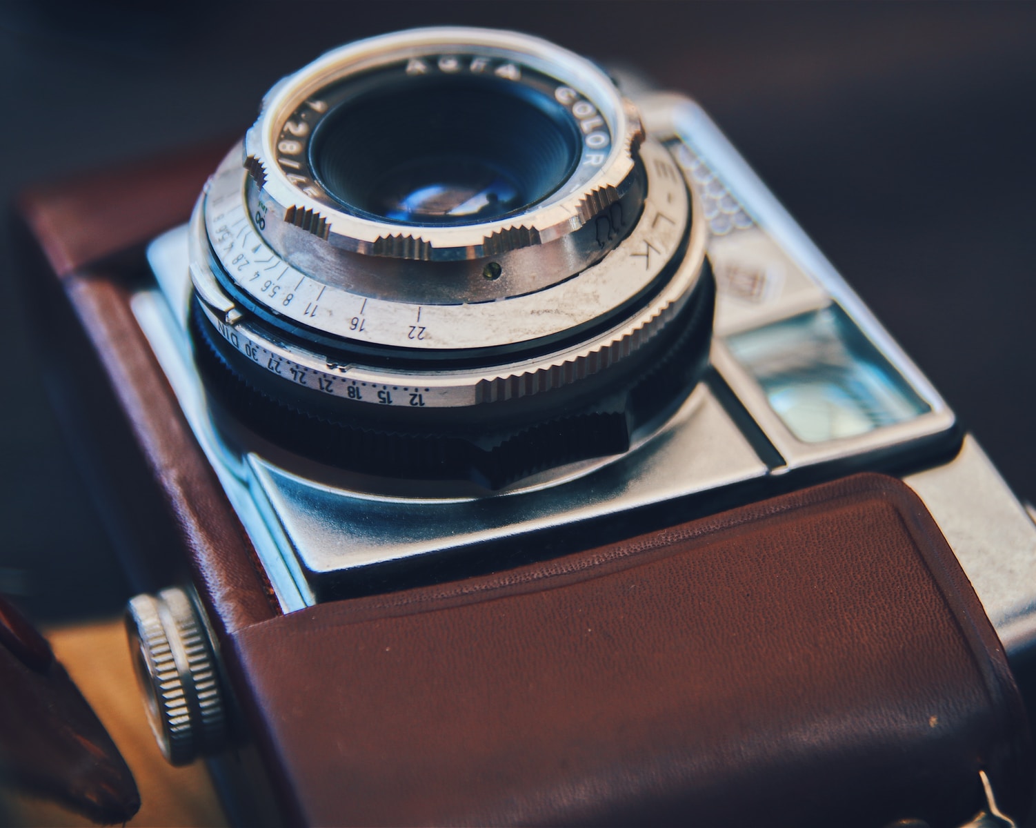 silver DSLR camera with brown leather case